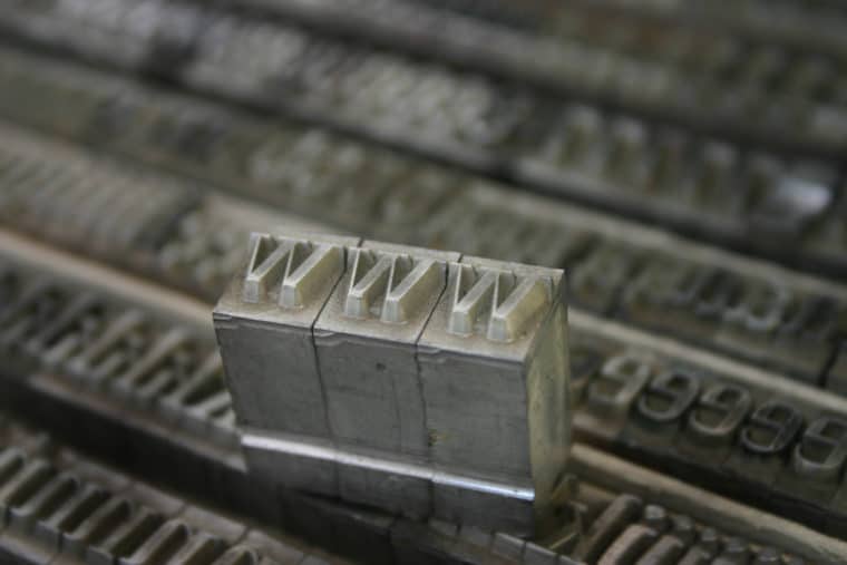 Image of movable type from a printing press spelling out "www"