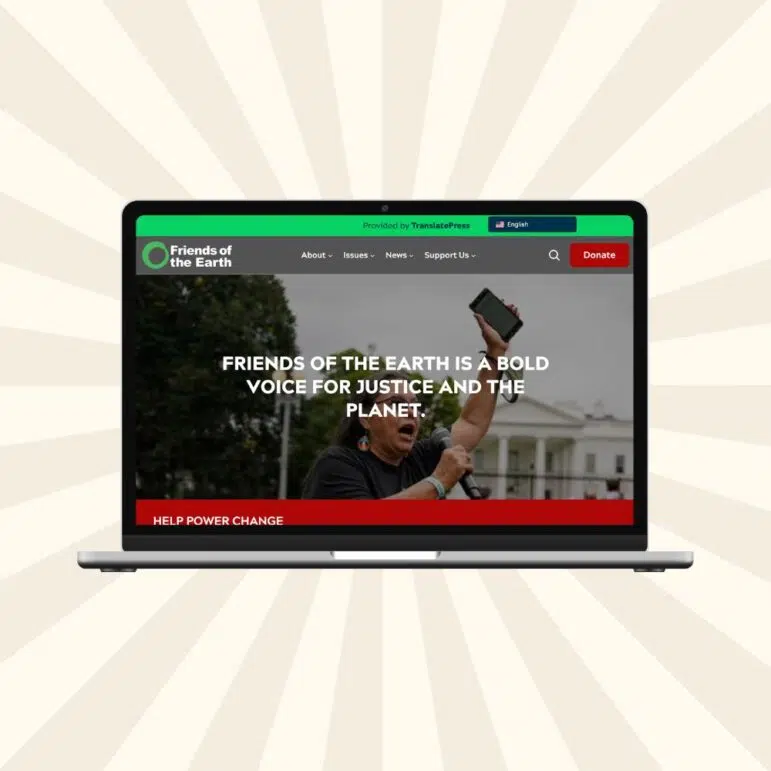 A laptop displays standout nonprofit web design on the Friends of the Earth website, featuring a person with a megaphone before the White House and the text: “Friends of the Earth is a bold voice for justice and the planet.”.