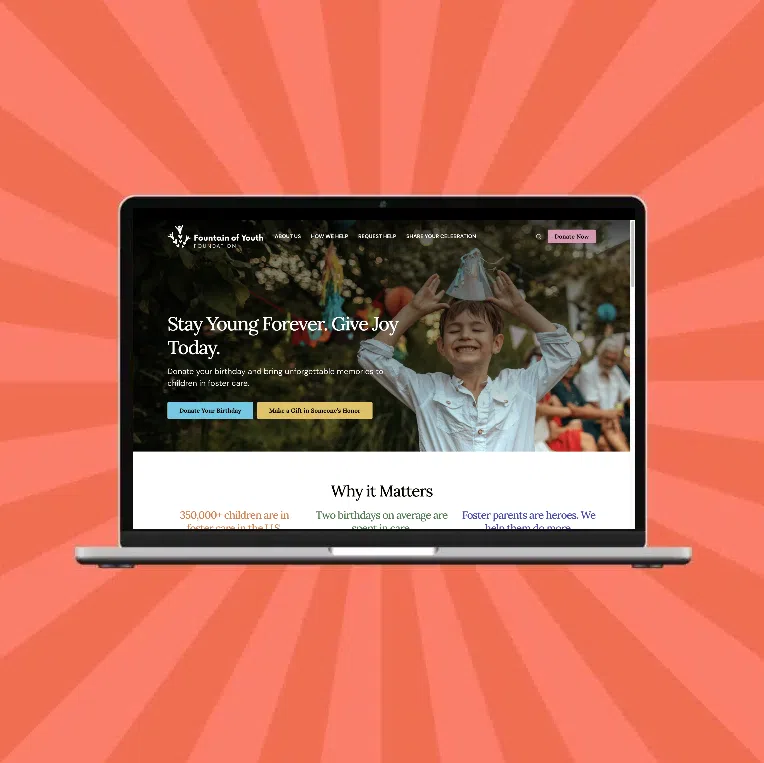 A laptop displays an open website for digital marketing for associations, featuring a smiling child in a party hat and the headline Stay Young Forever. Give Joy Today. The background bursts with a vibrant red starburst pattern.